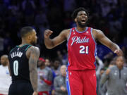 Philadelphia 76ers' Joel Embiid, right, reacts past Portland Trail Blazers' Damian Lillard after the 76ers won an NBA basketball game, Friday, March 10, 2023, in Philadelphia.