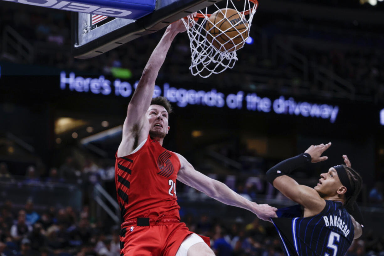 Portland Trail Blazers forward Drew Eubanks dunks the ball over Orlando Magic forward Paolo Banchero (5) during the first half of an NBA basketball game, Sunday, March 5, 2023, in Orlando, Fla.