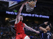 Portland Trail Blazers forward Drew Eubanks dunks the ball over Orlando Magic forward Paolo Banchero (5) during the first half of an NBA basketball game, Sunday, March 5, 2023, in Orlando, Fla.