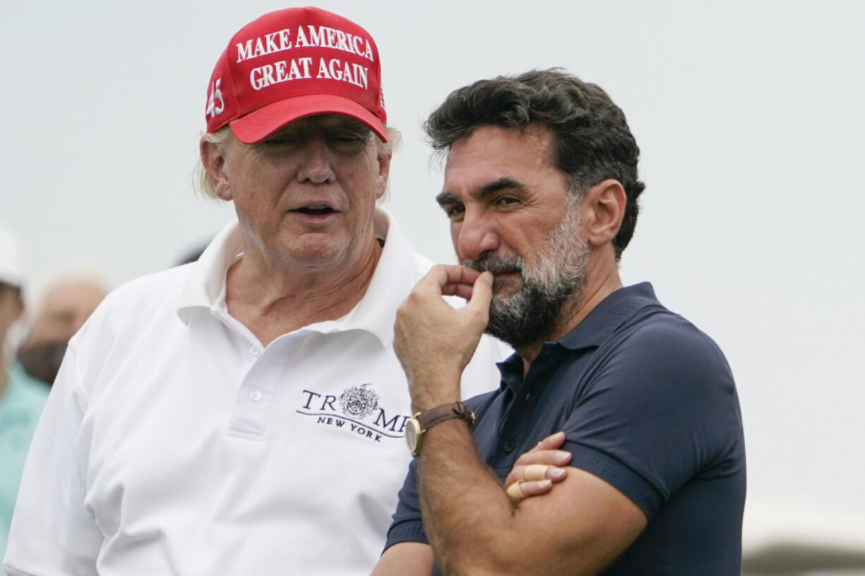 FILE - Former President Donald Trump, left, talks with Yasir Al-Rumayyan, governor of Saudi Arabia's Public Investment Fund, on the 16th hole during the first round of the Bedminster Invitational LIV Golf tournament in Bedminster, NJ., July 29, 2022.