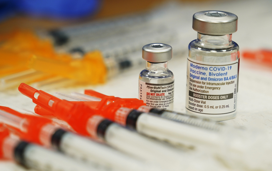 FILE - Pfizer, left, and Moderna bivalent COVID-19 vaccines are readied for use at a clinic on Nov., 17, 2022, in Richmond. Va. President Joe Biden's order that federal employees get vaccinated against COVID-19 was blocked Thursday, March 23, 2023, by a federal appeals court.