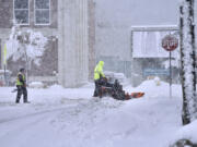 A worker plows snow on a street, Tuesday, March 14, 2023, in Pittsfield, Mass. The New England states and parts of New York are bracing for a winter storm due to last into Wednesday.