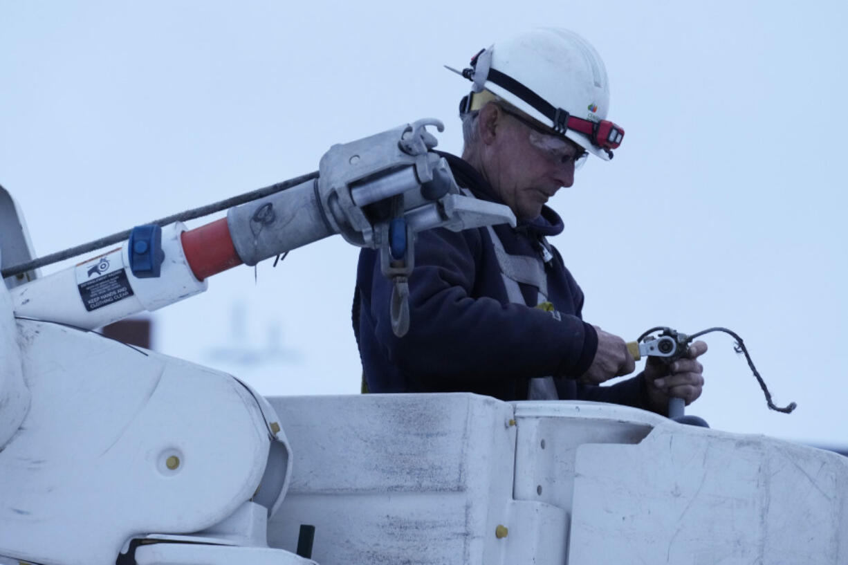 Central Maine Power Co. lineman John Baril works to restore electricity, Wednesday, March 15, 2023, in Lewiston, Maine. A late-winter storm dumped heavy, wet snow on parts of the Northeast, causing tens of thousands of power outages. (AP Photo/Robert F.