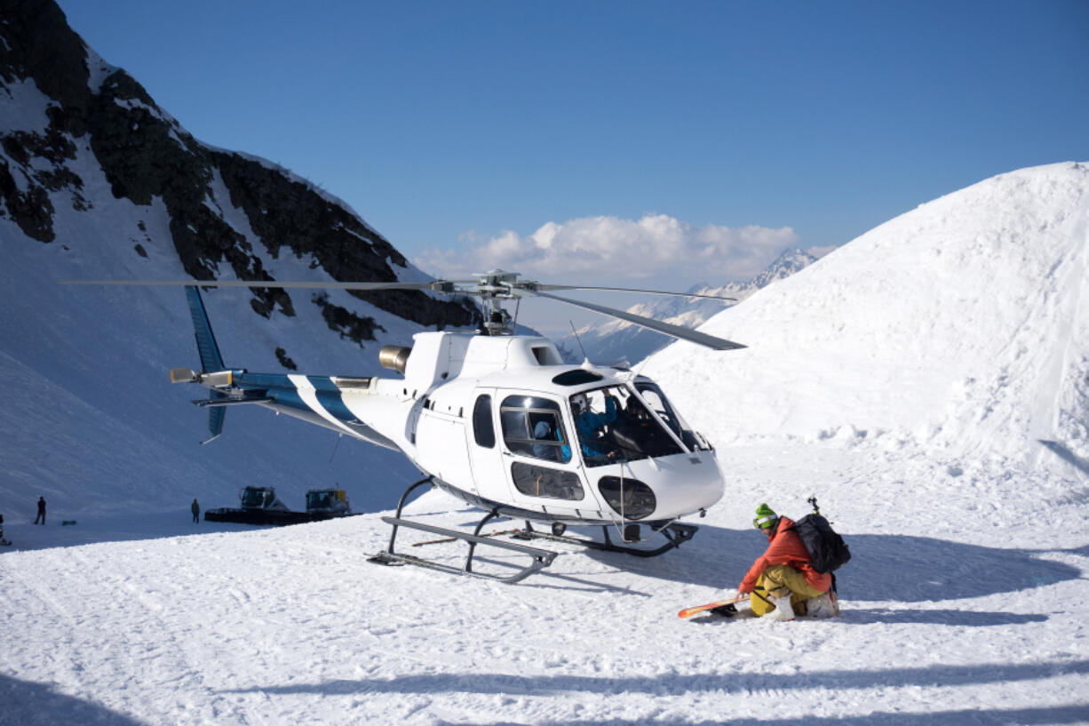 Rescue helicopter operates in snowy mountains.