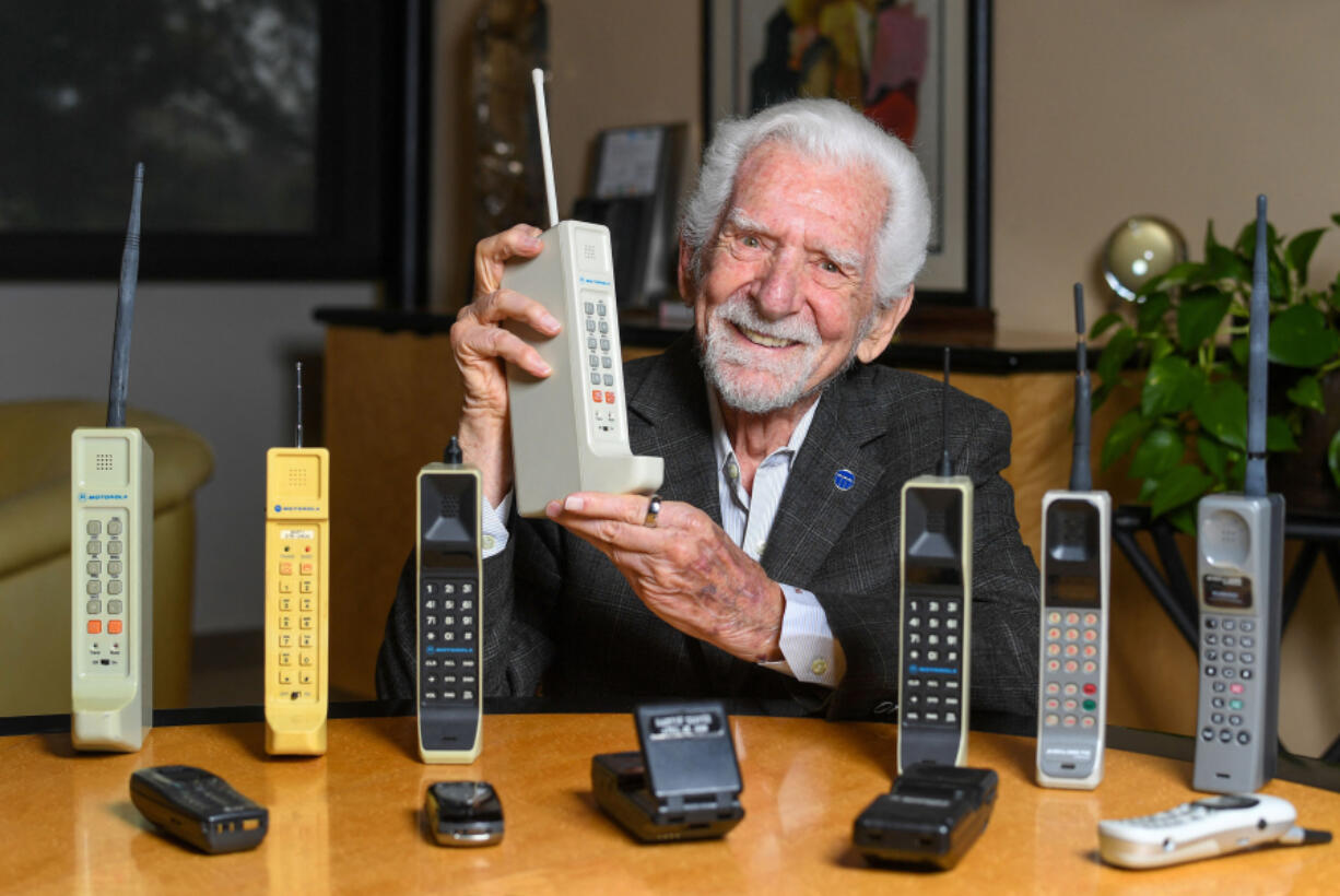 TOPSHOT - Engineer Martin Cooper holds a contemporary copy of the original cell phone he used to make the first cell phone call on April 3, 1973, in Del Mar, California on March 20, 2023.