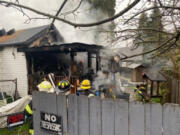 Vancouver firefighters extinguish a house fire Wednesday morning in the Rose Village neighborhood. Two people were taken to an area hospital, and several pets apparently died in the fire.