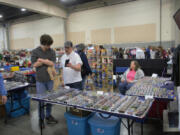 Travis Zimmerly, center, shows a prospective buyer a rare Hot Wheels car he's got in his vast collection Saturday at the Northwest's Largest Garage Sale at the Clark County Event Center at the Fairgrounds.