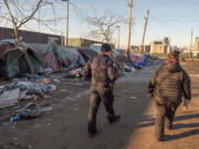 Vancouver Homelessness Response Coordinator and HART member Jamie Spinelli, at right, and Vancouver police Officer Tyler Chavers perform outreach duties at an encampment near the Share House men's shelter in downtown Vancouver in December 2022.