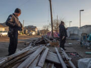 Vancouver Homelessness Response Coordinator and HART member Jamie Spinelli, at right, and Vancouver police Officer Tyler Chavers talk with encampment residents near the Share House men's shelter in December.