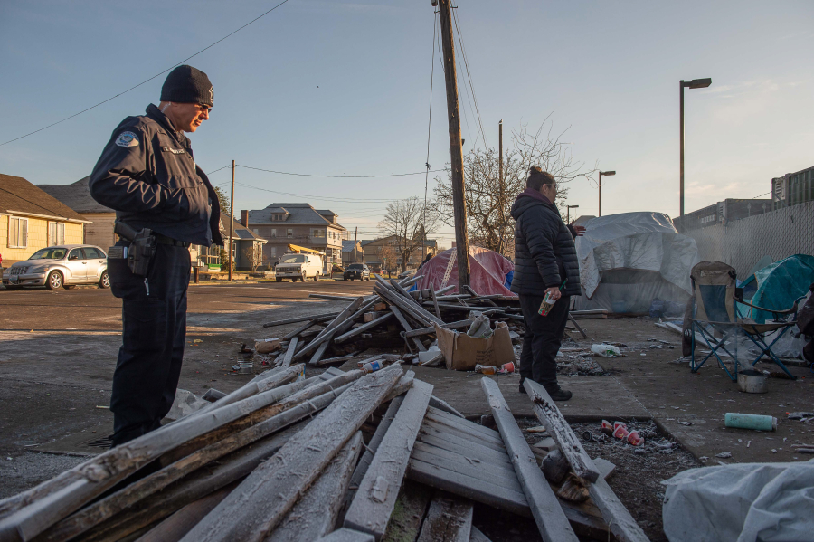 Vancouver Homelessness Response Coordinator and HART member Jamie Spinelli, at right, and Vancouver police Officer Tyler Chavers talk with encampment residents near the Share House men's shelter in December.