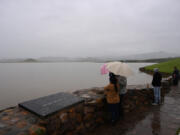 People look on at a full pool of water behind Schafer Dam, forming Lake Success on the Tule River in the Central Valley during a winter storm in Tulare County east of Porterville, California on March 21, 2023. (Patrick T.