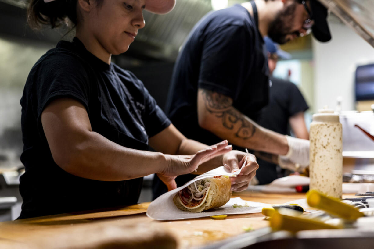 Cooks prepare sandwiches on a counter at Bub and Pop's on Aug. 19, 2022, in Washington, DC.