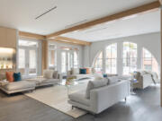 An expansive living room is kept open and airy through the use of neutral sofas and seating.