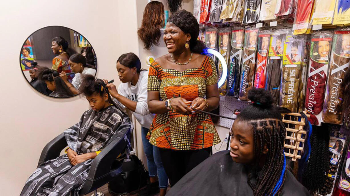Sonia Ekemon, center, styles box braids for her daughter, Catherine, 12, at African Braiding Salon by Sonia Ekemon, her business located at Phenix Salon Suites in Meridian, Idaho. (Sarah A.