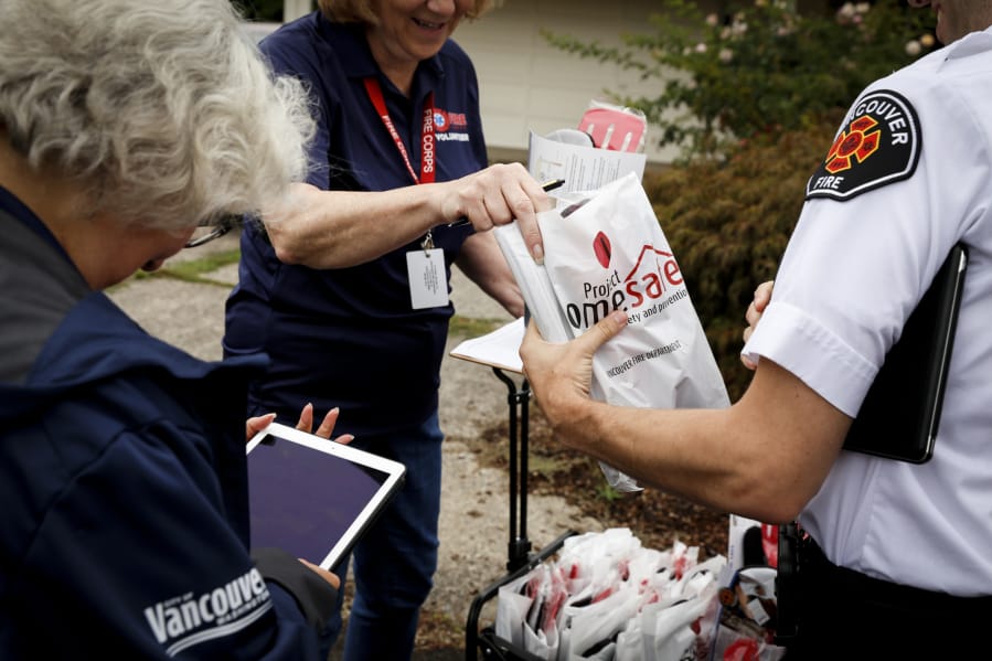 Paula Person, from left, Vancouver Mayor Anne McEnerny-Ogle, and Cale Baker prepare to go door to door to hand out education materials as a part of Project Safe Home in 2019.