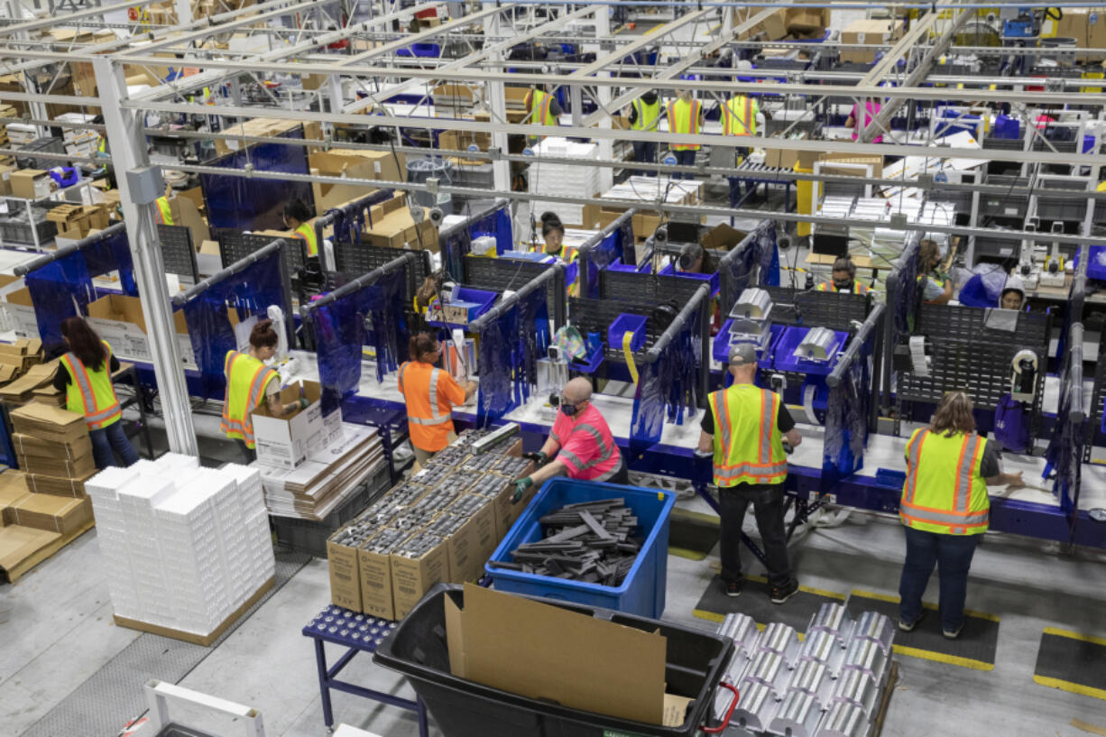 Workers assemble products and packaging in the manufacturing department at Hawthorne Gardening Co. in 2021. The company, which announced two layoffs at its Vancouver operation last year, recently reported a 31 percent loss in net sales.