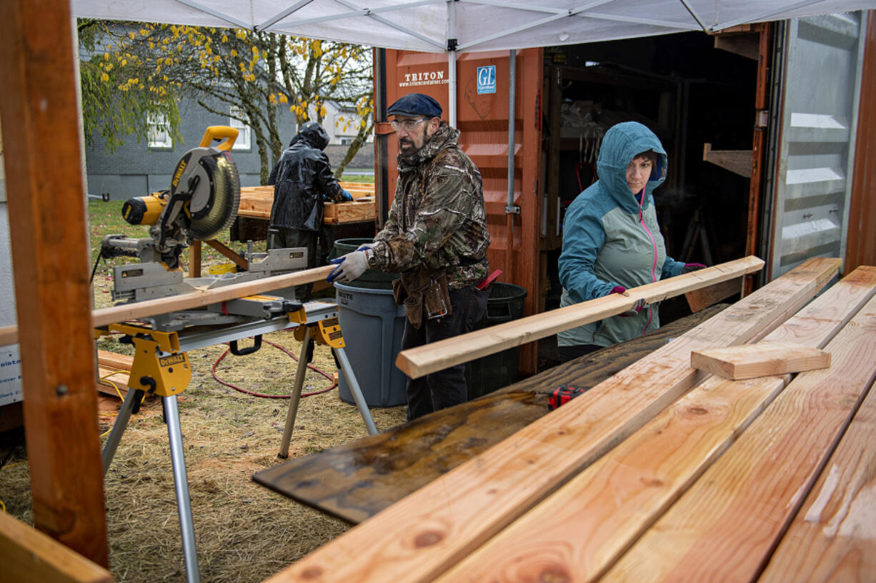 Volunteer Doug Corso, with hat, joins construction coordinator Jess Reynolds in November 2022 at Evergreen Habitat for Humanity's Johnson Village, a subdivision in east Vancouver that will house nine low-income families.