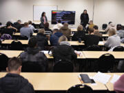 Ukrainian refugees take in a job-hunt orientation session at Partners in Careers in Vancouver. Recent Ukrainian refugee and PIC employment specialist Sasha Cheban, left, translates into Ukrainian while employment specialist Kegan Gibson, right, gives a talk in English about resumes and cover letters.