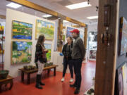 Maria Gonser of Attic Gallery, left, chats with Camas residents Robin and Kit Blair who were checking out artworks on a recent Friday morning.