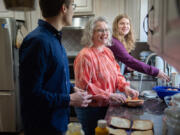 Ingela Martinson, center, prepares lunch with her sons Andreas, left, and Nathan, right, during a break from watching the The Church of Jesus Christ of Latter-Day Saints general conference broadcast on April 1. They are mourning the death of Göran Martinson, husband and father. Their faith's promise of eternal families sustains them.