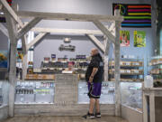 Budtender Tabbie Tirey, left, chats with Brandon Nickell, head of security, while working at Orchards Cannabis Market.