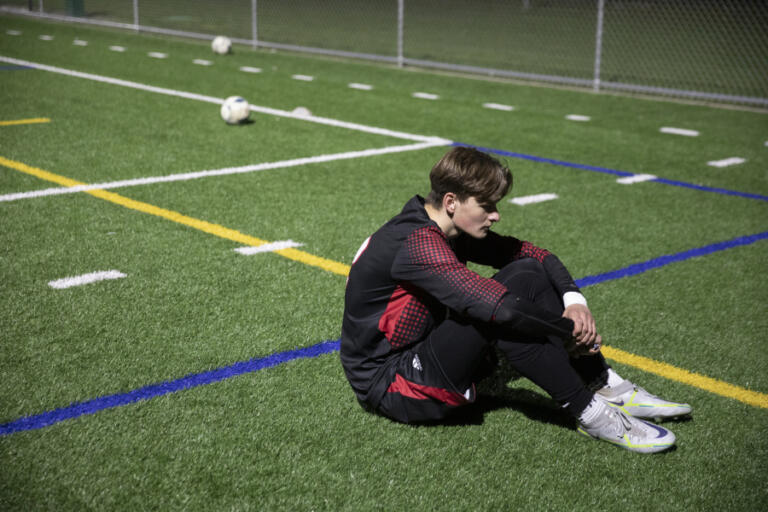 Stanislav Horiuk sits on the field after the Trappers 1-0 loss to Washougal on April 13. Horiuk arrived from Ukraine in 2019 and is a cousin of Illia Strynada.