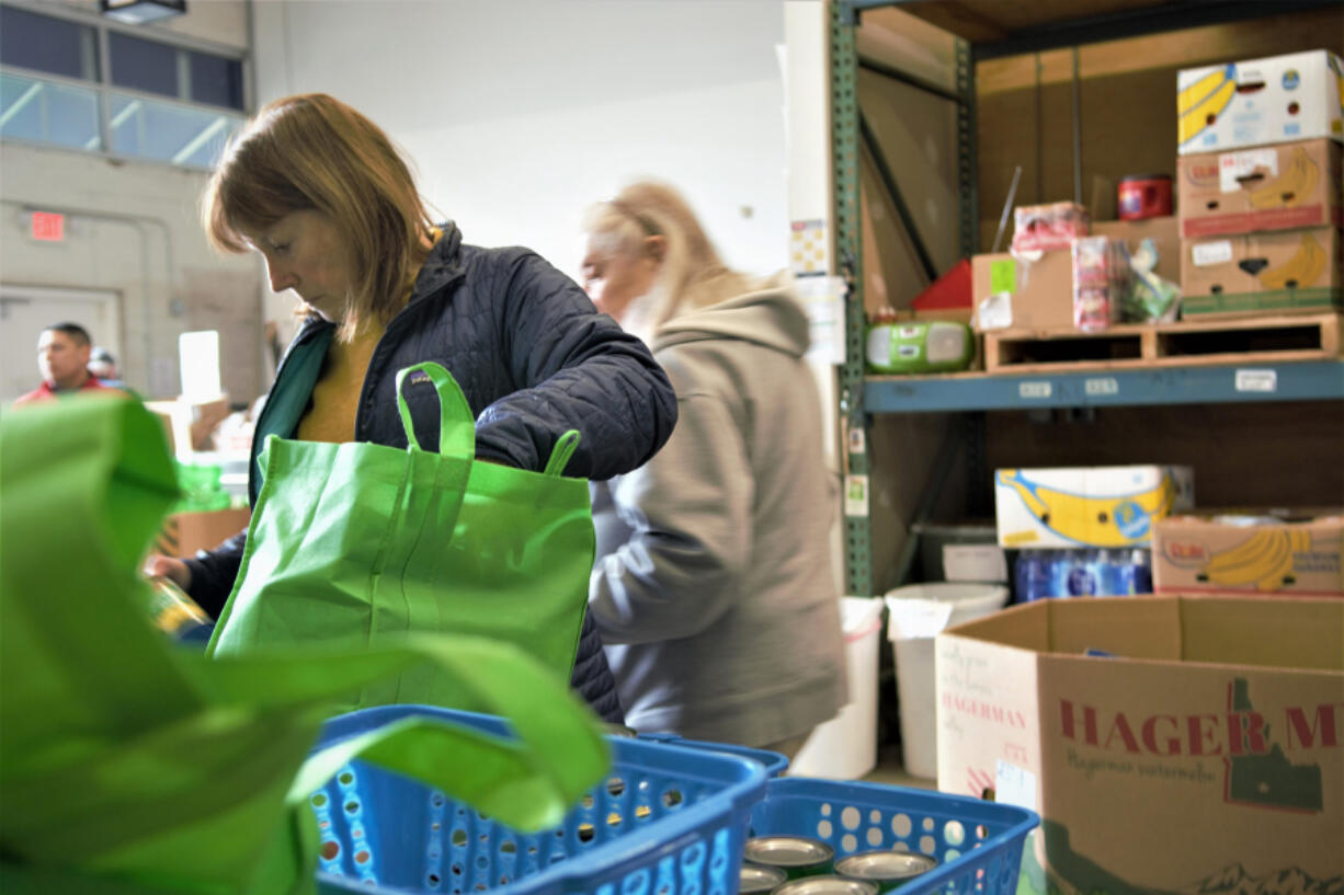 Alicia Ewert sorts food from donation bags into specific boxes. Ewert is a member of Catch-22, a local dragon boat racing team that volunteered for the Clark Neighbors Food Project drive.