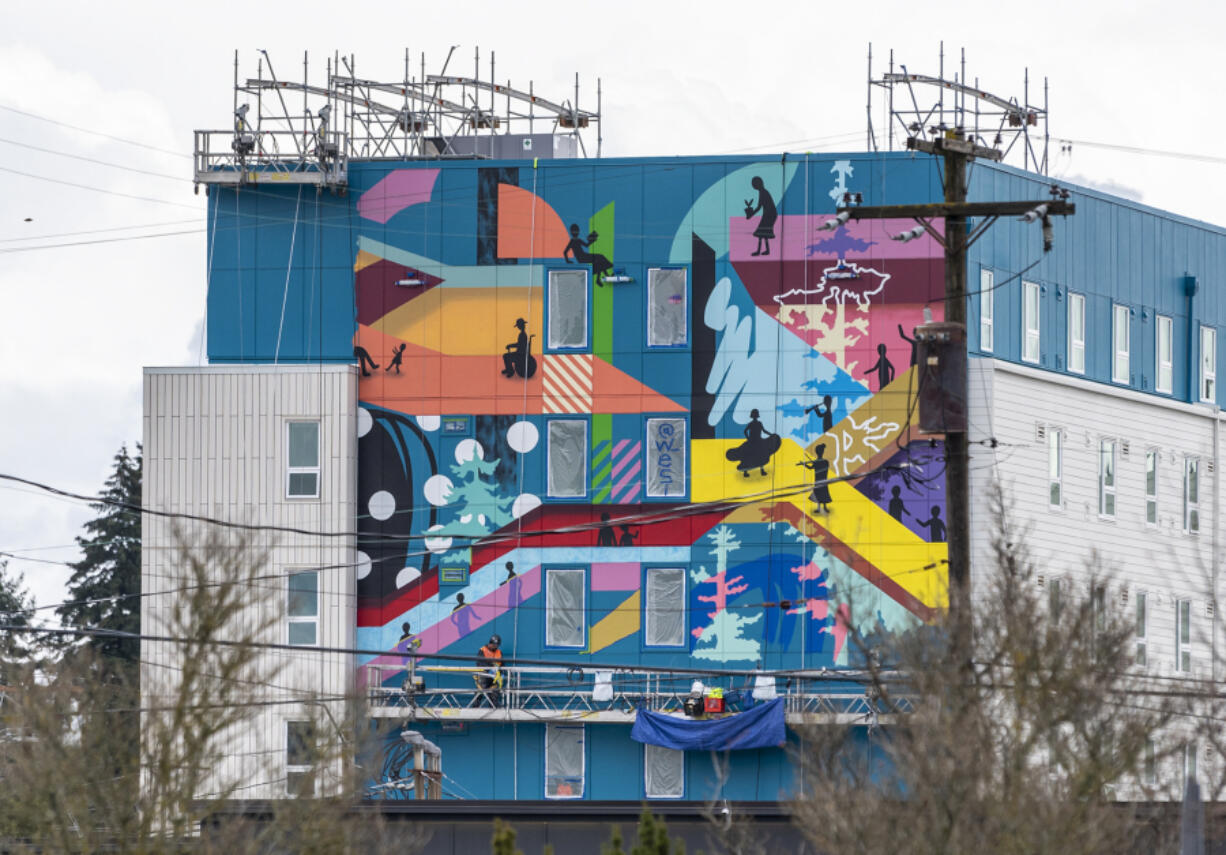 Portland-based artist Christian T?llez works on a mural Tuesday at the Fourth Plain Community Commons building. The mural is called "Step Up" and is credited to the Portland Street Art Alliance, fellow local muralist Alex Chiu and T?llez, according to a city of Vancouver Instagram post.