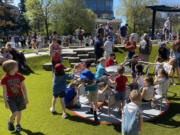 Children play on the merry-go-round at the newly reopened Esther Short Park in downtown Vancouver. The merry-go-round is at ground level and has seats to make it more accessible to kids with different abilities.