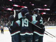 Seattle Kraken left wing Jared McCann (19) and teammates celebrate his goal against the Arizona Coyotes during the first period of an NHL hockey game Thursday, April 6, 2023, in Seattle.