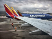 FILE - A Southwest Airlines ground crew directs a plane out of the terminal at Hollywood Burbank Airport in Burbank, Calif. on Feb. 14, 2023.