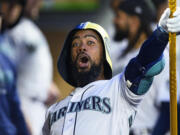 Seattle Mariners' Teoscar Hernandez celebrates his home run against the St. Louis Cardinals with a helmet and trident in the dugout during the fourth inning of a baseball game Friday, April 21, 2023, in Seattle.