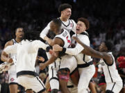 San Diego State guard Lamont Butler (5) celebrates with teammates after scoring the winning basket against Florida Atlantic during a Final Four college basketball game in the NCAA Tournament on Saturday, April 1, 2023, in Houston.