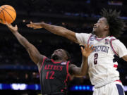 Connecticut guard Tristen Newton (2) blocks a shot by San Diego State guard Darrion Trammell during the second half of the men's national championship college basketball game in the NCAA Tournament on Monday, April 3, 2023, in Houston. (AP Photo/David J.