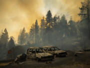 FILE - Scorched vehicles rest in a clearing as the Mosquito Fire burns along Michigan Bluff Rd. in unincorporated Placer County, Calif., Sept. 7, 2022. An overwhelming majority of the U.S. public say they have recently experienced extreme weather, and most of them attribute that to climate change, according to a new poll from The Associated Press-NORC Center for Public Affairs Research.