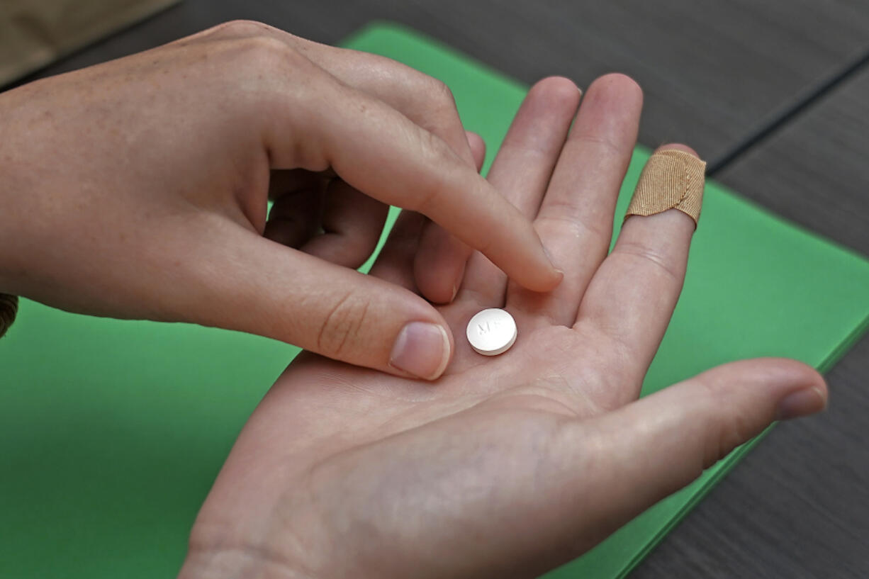 FILE - A patient prepares to take the first of two pills for a medication abortion during a visit to a clinic in Kansas City, Kan., on Wednesday, Oct. 12, 2022. Some abortion clinics are fielding lots of calls from patients since a Friday, April 7, 2023 court ruling threatened the availability of a main drug used in medication abortion, mifepristone. Patients are concerned about whether they can still get the care they need.