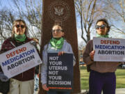 FILE - Three members of the Women's March group protest in support of access to abortion medication outside the Federal Courthouse on Wednesday, March 15, 2023 in Amarillo, Texas. Matthew Kacsmaryk, a Texas judge who sparked a legal firestorm with an unprecedented ruling halting approval of the nation's most common method of abortion, Friday, April 7, 2023, is a former attorney for a religious liberty legal group with a long history pushing conservative causes.