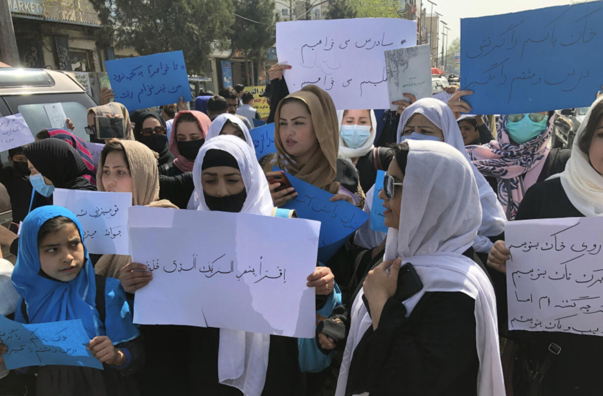 FILE - Afghan women chant and hold signs of protest during a demonstration in Kabul, Afghanistan, March 26, 2022. The U.N. said Wednesday, April 5, 2023, that it cannot accept a Taliban decision to bar Afghan female staffers from working at the agency, calling it an "unparalleled" violation of women's rights.