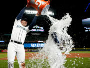 Seattle Mariners first baseman Ty France douses Teoscar Hernandez, who had hit two home runs against the Los Angeles Angels in a baseball game Tuesday, April 4, 2023, in Seattle.