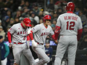 Los Angeles Angels designated hitter Shohei Ohtani, center, celebrates after his two-run home run against the Seattle Mariners which also scored teammate Mike Trout, left, as Hunter Renfroe (12) looks on in the fifth inning during a baseball game Monday, April 3, 2023, in Seattle.