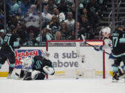 Seattle Kraken's Daniel Sprong (91) and goaltender Philipp Grubauer (31) look on after a goal by Colorado Avalanche center Nathan MacKinnon on Saturday in Seattle.