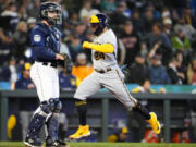 Milwaukee Brewers' William Contreras scores on a single by Luke Voit, while Seattle Mariners catcher Tom Murphy looks to the infield during the seventh inning of a baseball game Wednesday, April 19, 2023, in Seattle.