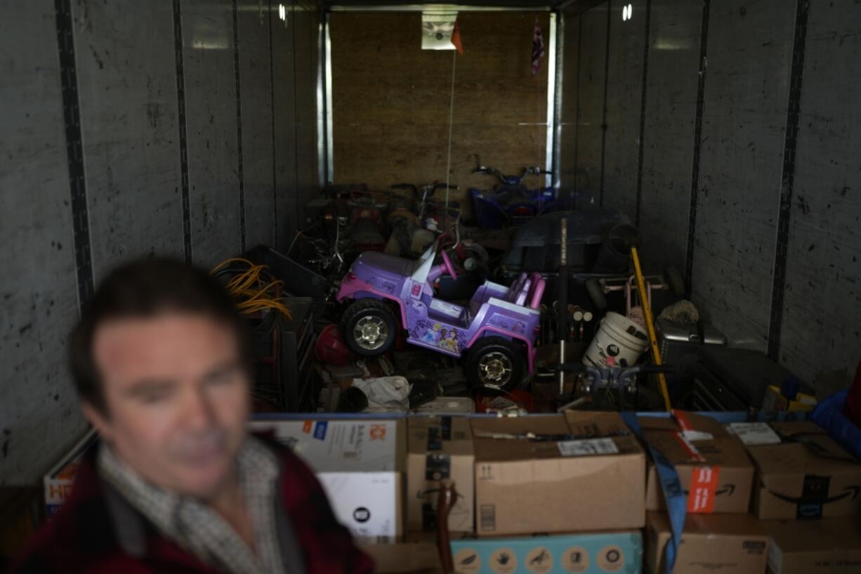 Ron Caetano stands in a trailer packed with his family's belongings in anticipation of flooding of the Kings River in the Island district of Lemoore, Calif., Wednesday, April 19, 2023. Caetano packed photos and valuables in a trailer and food in carry totes so he can leave home in less than an hour should the river water rush in. (AP Photo/Jae C.