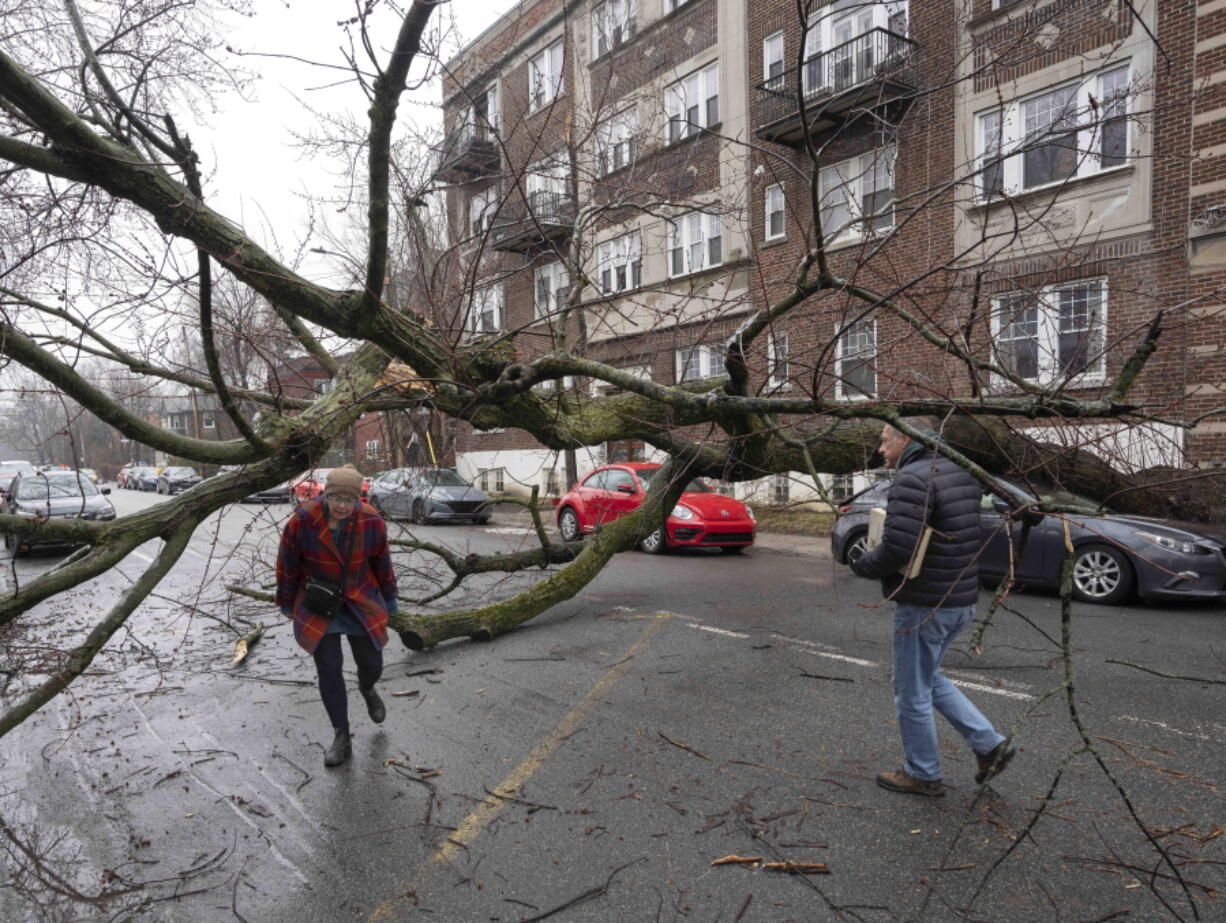 Pedestrians make their way around debris in Montreal, Thursday, April 6, 2023 after an ice storm which left more than a million customers without power in Quebec.