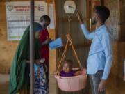 FILE - A child is weighed at a camp for displaced people amid a drought on the outskirts of Dollow, Somalia, Sept. 19, 2022.  Looking back at 2022's weather with months of analysis, the World Meteorological Organization says last year really was as bad as it seemed.