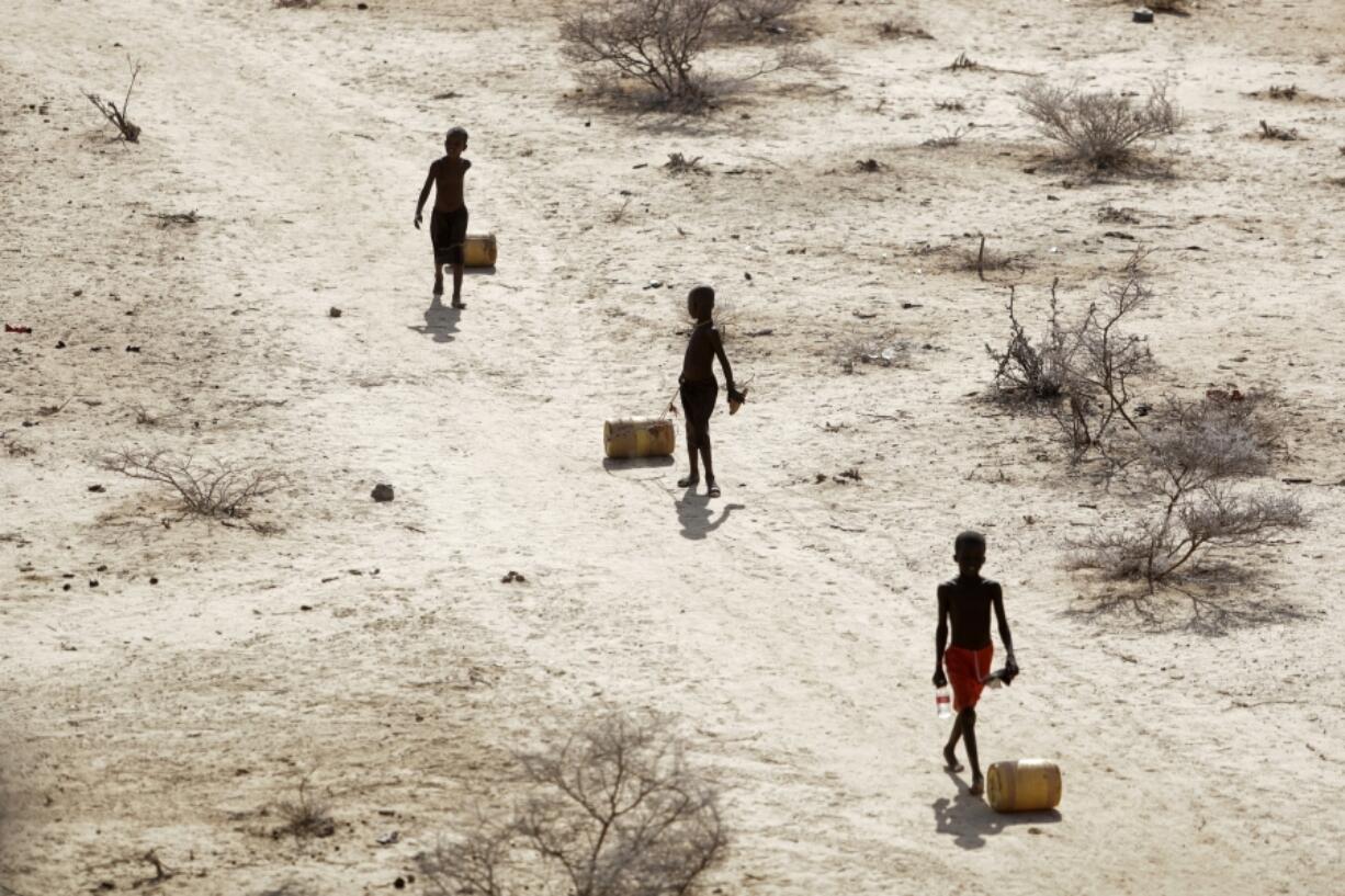 FILE - Young boys pull containers of water as they return to their huts from a well in the village of Ntabasi village amid a drought in Samburu East, Kenya, on Oct, 14, 2022. An international team of climate scientists says the ongoing drought in Eastern Africa has been made worse by human-induced climate change according to a report from World Weather Attribution.