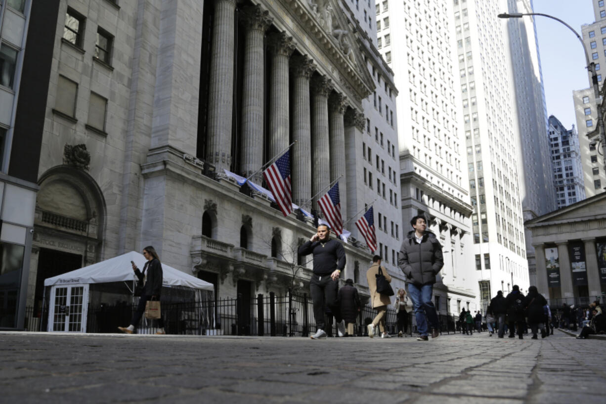 FILE - People pass the front of the New York Stock Exchange in New York, March 21, 2023. Stocks are dipping on Wall Street, Wednesday, April 5, and Treasury yields are dropping following the latest signals that the U.S. economy is slowing under the weight of much higher interest rates.