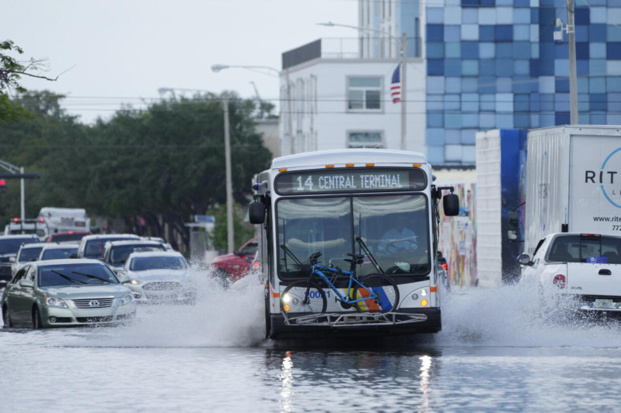 A city bus makes its way through receding floodwaters on Avenue of the Arts in Fort Lauderdale, Fla., Thursday, April 13, 2023. Over 25 inches of rain fell in South Florida since Monday, causing widespread flooding.