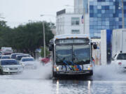 A city bus makes its way through receding floodwaters on Avenue of the Arts in Fort Lauderdale, Fla., Thursday, April 13, 2023. Over 25 inches of rain fell in South Florida since Monday, causing widespread flooding.