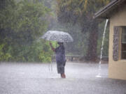 A man stops to take pictures of his flooded neighborhood along SW 3rd Street and SW 4th Ave in Dania Beach, Fla., on Wednesday, April 12, 2023.